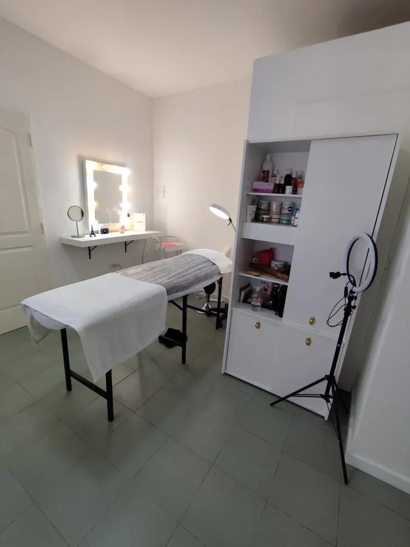 Consultorio de Moreno: camilla, espejo con luces y mueble con productos